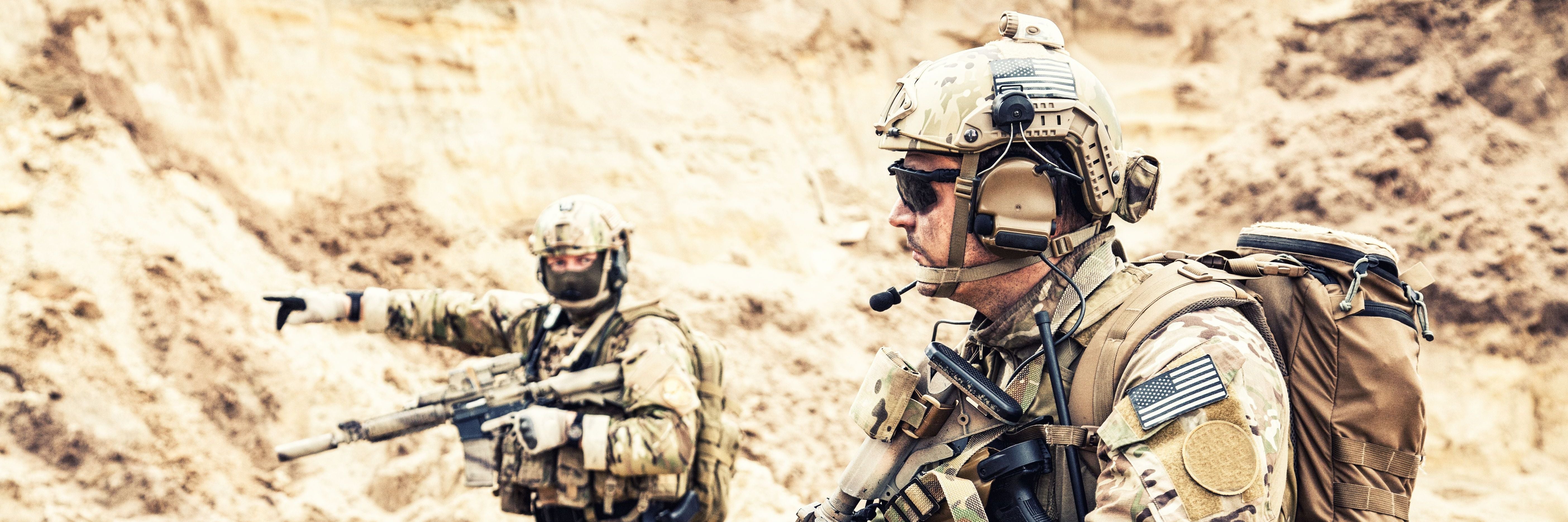 Two men wearing U.S. military unifroms with ballistic helmets and 3M comtac headsets.